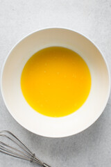 Organic melted butter in a white bowl, natural butter from grass fed cows
