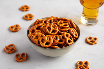 Mini Pretzels with Salt in a Bowl on a gray background, side view.