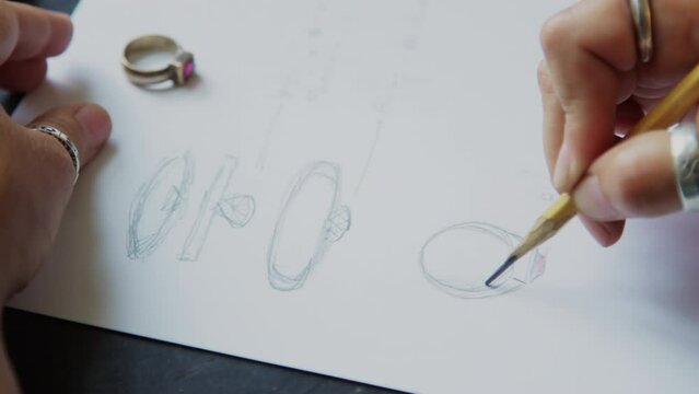 Goldsmith designing ring making sketch on paper