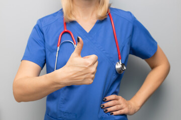 doctor in uniform in hospital holding thumb up.