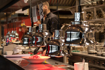 coffee shop window. Professional cuisine in a modern restaurant. Plate of food heating up in heat lamps.