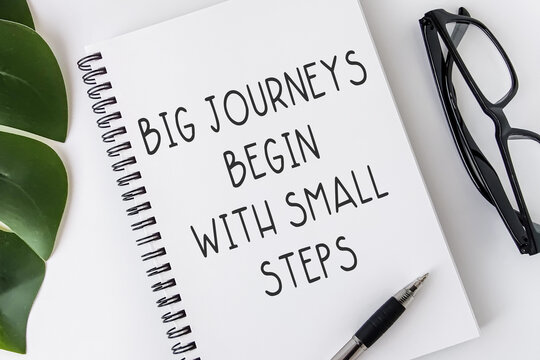 Big journeys begin with small steps. Text on notebook. Inspiring Creative Motivation Quote.