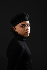 Obraz premium portrait of young african american man in trendy beret and turtleneck looking at camera isolated on black