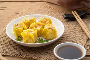 Shumai or Chinese Steamed Dumpling,meatball dumpling with wanton skin in with plate,served with soy sauce