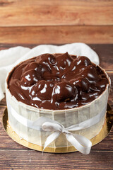 Profiterole cake. Cake with profiteroles surrounded by white chocolate on a wood background. close up
