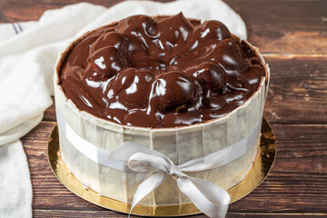 Profiterole cake. Cake with profiteroles surrounded by white chocolate on a wood background. close up