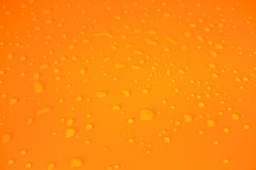 Defocus blurred transparent orange-colored water drop clear calm water surface texture with splashes and bubbles. Trendy abstract nature background. Water waves in sunlight with copy space.