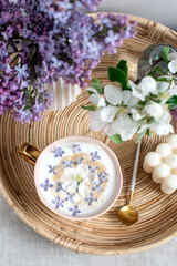 Naturals soy candle, cup with cappuccino, spring flowers lilac, woman's day