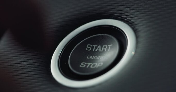 Macro of a Man's Finger Pushing the Button to Start his Vehicle's Engine. Businessman Starting his new Luxurious car bought from an auto dealership. Transition Shot of Starting or Stopping Car Engine