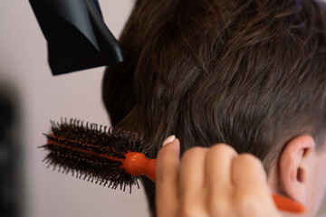 Closeup asian female barber making haircut for male customer with male hairstyle in qualified...