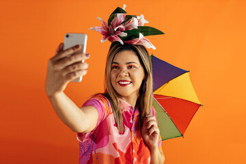 Plakat Brazilian Carnival. Studio shot of young woman celebrating carnival taking a selfie.