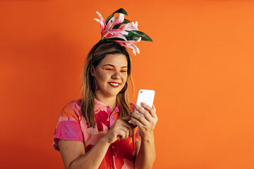 Brazilian Carnival. Studio shot of young woman in carnival costume using smartphone.