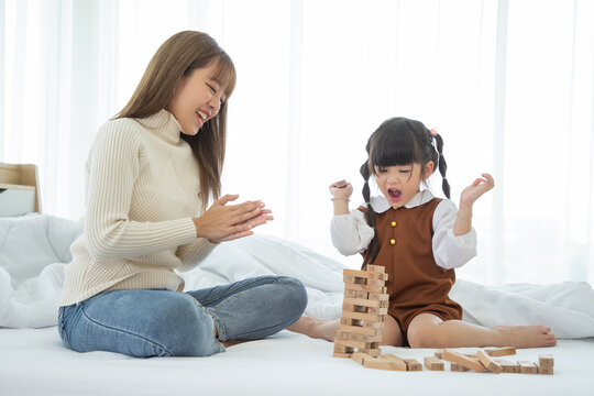Happy loving family. Asian mother and her daughter child girl playing in bedroom.