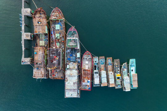 Aerial view of assorted traditional fishing boats lined up in a row, Indonesia