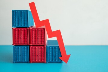 Red economy graph chart falling down collapse with containers on wooden table white wall background copy space. Global economic recession crisis, FED increase hike interest rates, inflation, GDP down.