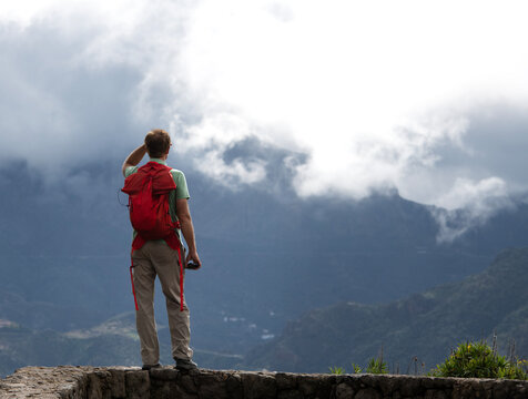 Rear view of a male hiker standing in mountains looking at view, Gran Canaria, Canary Islands, Spain