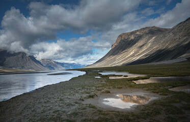 Water front view of mountains on Akshayuk Pass, Buffin Island, Canada. Pond reflections