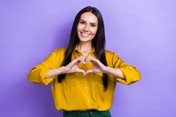 Photo of lovely positive girl toothy smile arms fingers demonstrate heart symbol isolated on violet color background