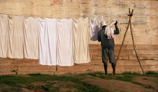 Adult Indian Man Facing Away Working Doing An Everyday Job, Hanging Out Washing On A Line In The Sun