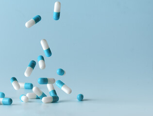 Falling blue white capsules on blue background.