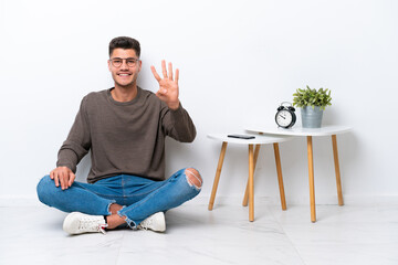 Young caucasian man sitting in his home isolated on white background happy and counting four with fingers