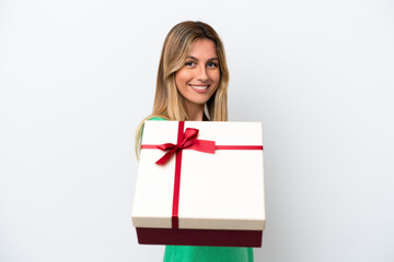 Young Uruguayan woman holding a gift isolated on white background with happy expression