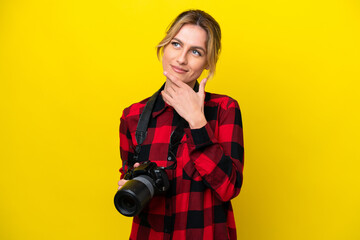 Uruguayan photographer woman isolated on yellow background having doubts and with confuse face expression