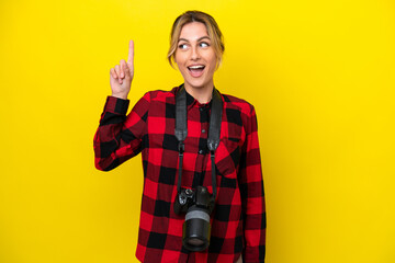 Uruguayan photographer woman isolated on yellow background intending to realizes the solution while lifting a finger up