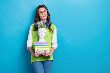 Photo of minded girl hold pile stack book sculpture vase flowers look empty space hesitate isolated...
