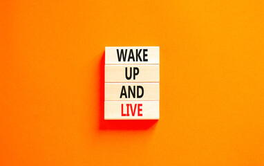 Wake up and live symbol. Concept words Wake up and live on wooden blocks. Beautiful orange table orange background. Business lifestyle wake up and live concept. Copy space.