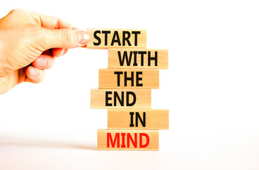 Start in end of mind symbol. Concept words Start with the end in mind on wooden blocks. Beautiful white table white background. Businessman hand. Business start in end of mind concept. Copy space.