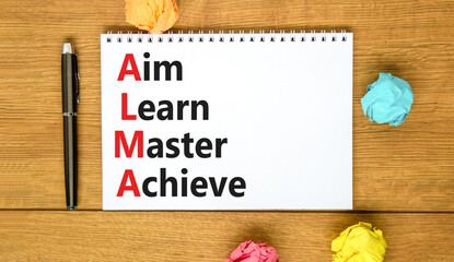 ALMA aim learn master achieve symbol. Concept words ALMA aim learn master achieve on white note on beautiful wooden background. Business ALMA aim learn master achieve concept. Copy space.