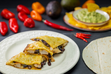 quesadilla with chicken meat and beans and guacamole with nachos