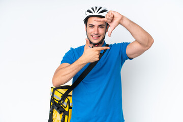 Young caucasian man with thermal backpack isolated on white background focusing face. Framing symbol