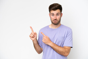 Fototapeta premium Young caucasian man isolated on white background frightened and pointing to the side