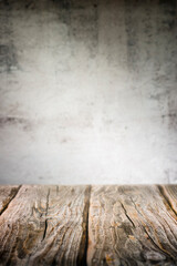 Wooden planks as table on damaged wall background