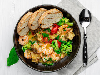 Shrimps in a creamy sauce with mushrooms, broccoli and various vegetables