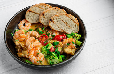 Shrimps in a creamy sauce with mushrooms, broccoli and various vegetables