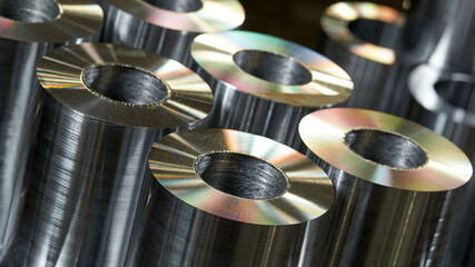 A lot of steel round pipes being processed on a milling machine