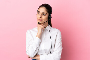 Young telemarketer over isolated background having doubts while looking up