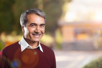 Happy senior smart man posing on background