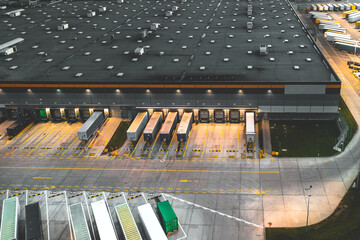 Aerial view of semi trailers with cargo trailers parked near logistics warehouses
