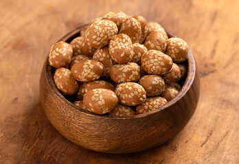 Bowl of Crunchy Asian Sesame Peanuts with Soy Sauce on a Wooden Counter
