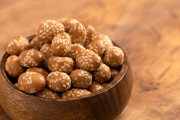 Bowl of Crunchy Asian Sesame Peanuts with Soy Sauce on a Wooden Counter