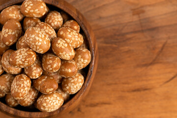 Bowl of Crunchy Asian Sesame Peanuts with Soy Sauce on a Wooden Counter