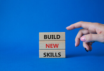Build New skills symbol. Concept word Build New skills on wooden blocks. Businessman hand. Beautiful blue background. Business and Build New skills concept. Copy space