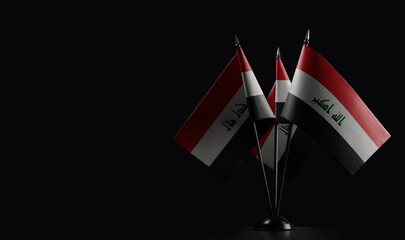 Small national flags of the Iraq on a black background