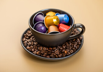 Cup with aluminium coffee capsules pods with fresh aroma coffee on beige background.