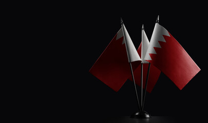 Small national flags of the Bahrain on a black background