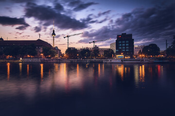 Fototapeta na wymiar Blaue Stunde am Spreeufer mit beleuchteten Gebäuden und Blick auf den Fernsehturm